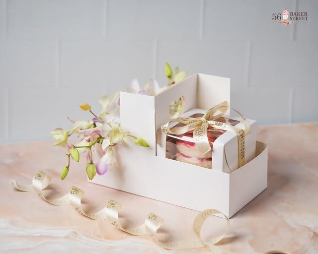 White gift caddy with orchids and a cake